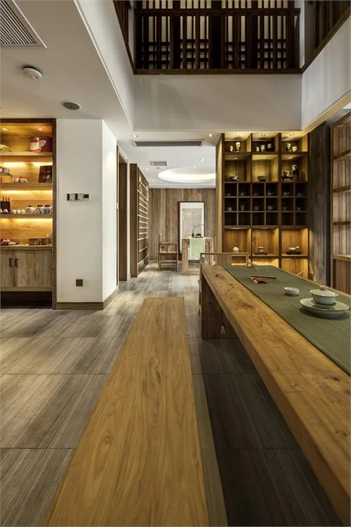 Long timber tea table leading toward illuminated display shelves