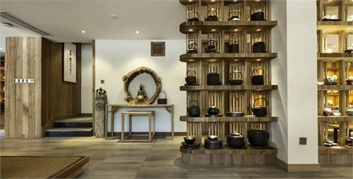 Teaware arranged on a sculptural timber rack beside a small alcove