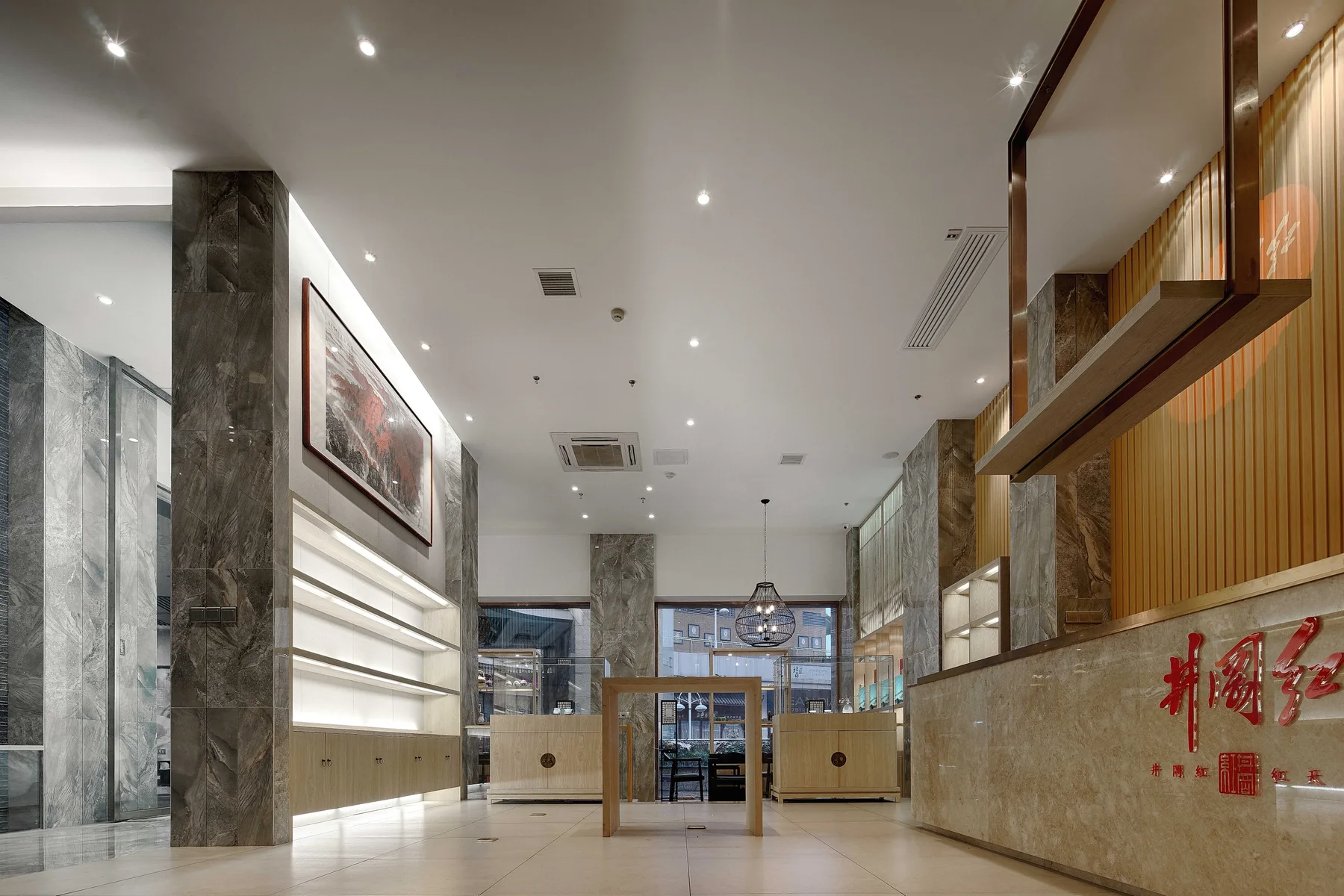 Bright tea club reception with stone columns and illuminated display shelves