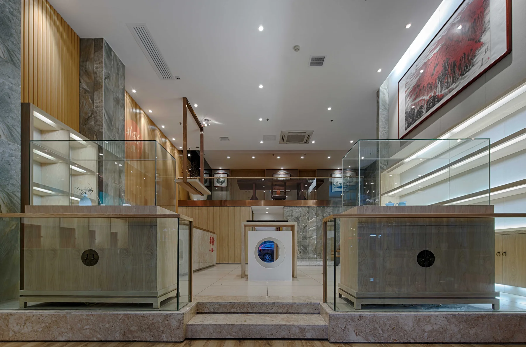 Symmetrical display cabinets opening toward the raised tea retail floor